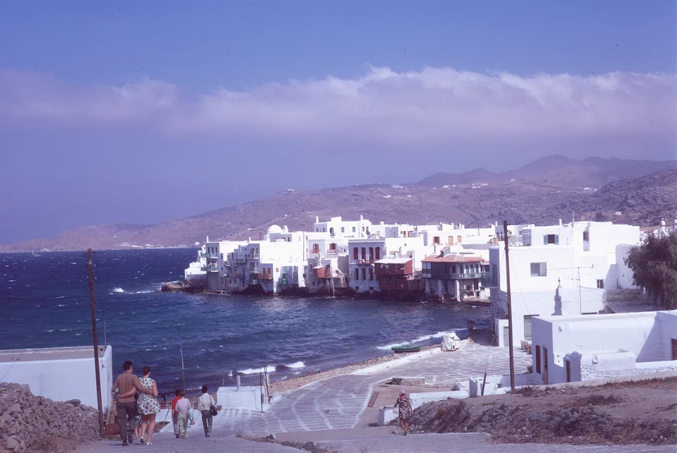 White waterfront buildings, waves and a descending path in Mykonos